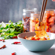 chopsticks dipping into a bowl of kimchi